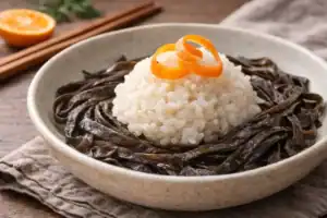 Cuenco con arroz, espagueti de mar y cítricos.