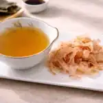 Cuenco lleno de caldo dashi japonés y copos de bonito seco.